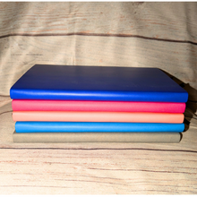 Load image into Gallery viewer, Stack of colorful books on a wooden surface
