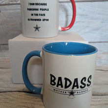 Load image into Gallery viewer, Two mugs in red and blue with humorous text designs on a wooden surface