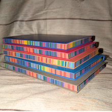 Load image into Gallery viewer, Stack of colorful books on a textured surface