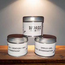 Load image into Gallery viewer, Three metal tins containing candles for runners with labels on a wooden surface